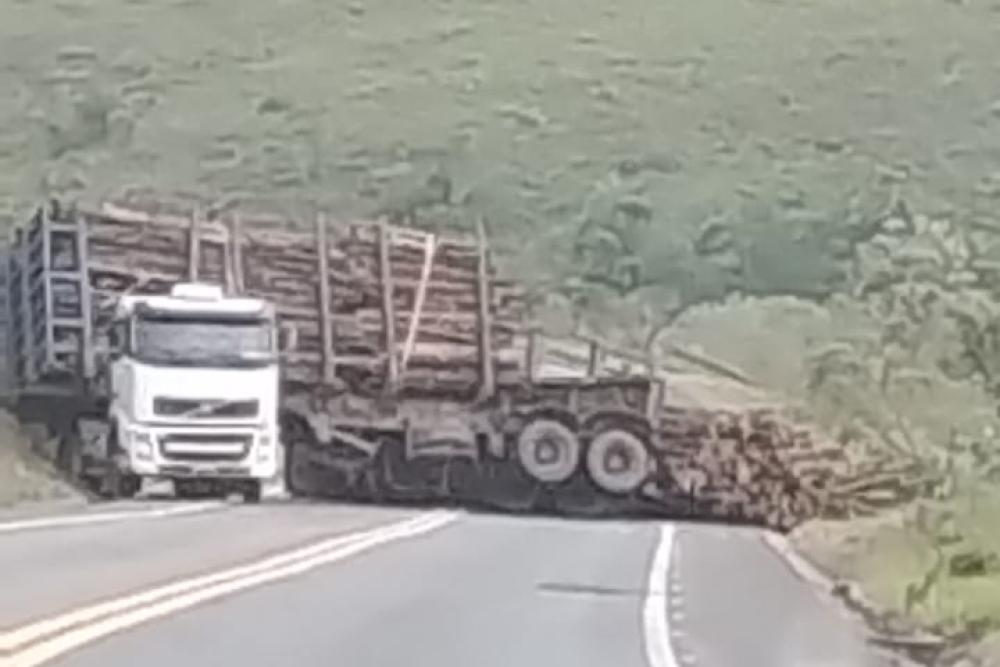 Carreta carregada de lenha tomba fechando pista em Tapira MG